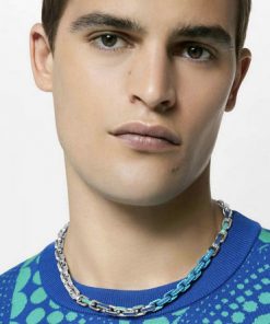 Man modeling chain necklace and patterned blue shirt