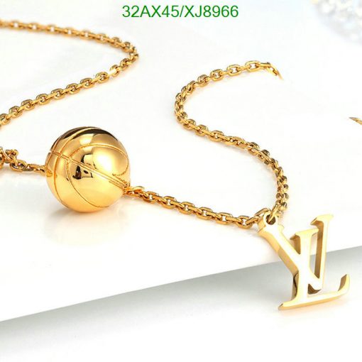 Gold necklace with spherical pendant and letter charm.