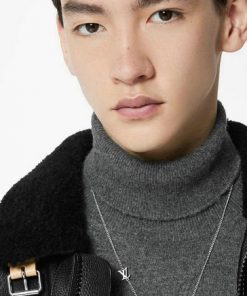 Man in turtleneck showcasing silver necklace and jacket.