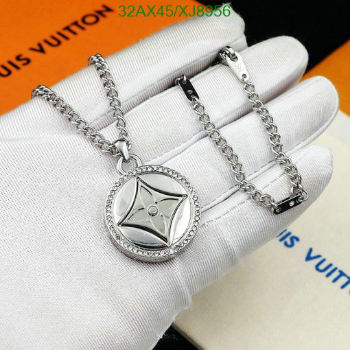 Silver pendant necklace on white gloved hand.