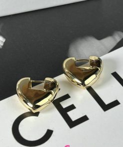 Gold heart-shaped earrings on printed material.