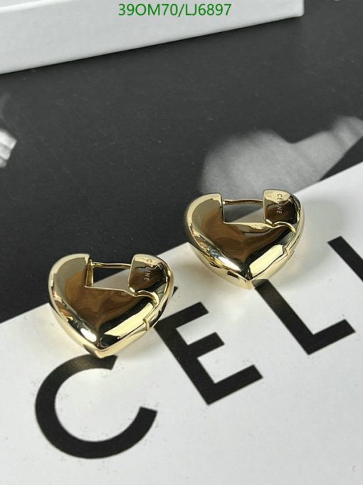 Gold heart-shaped earrings on branded background.