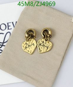 Gold heart "Love" earrings on beige surface with pouch.