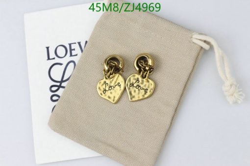 Gold heart "Love" earrings on beige surface with pouch.