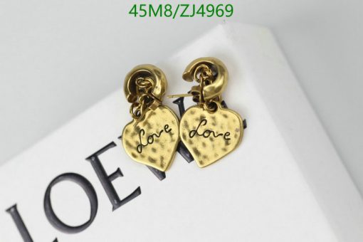 Gold heart-shaped "love" earrings on white surface.