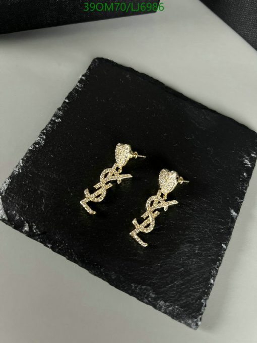 Gold dollar sign stud earrings on black surface.