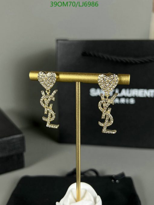 Heart-shaped crystal earrings on display stand.