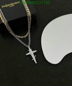 Gold and silver chains with airplane pendant on black background.