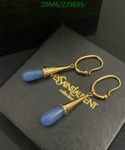 Gold earrings with blue pendant on black box.