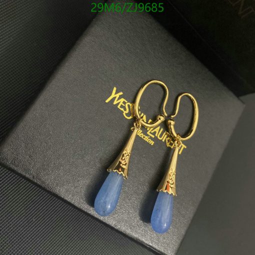 Gold and blue earrings on black case.