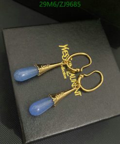 Gold and blue designer drop earrings on black box