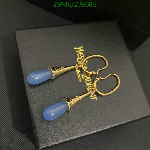 Gold and blue designer drop earrings on black box