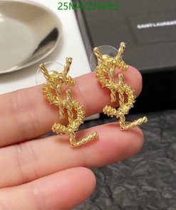 Gold twig-shaped earrings on finger.