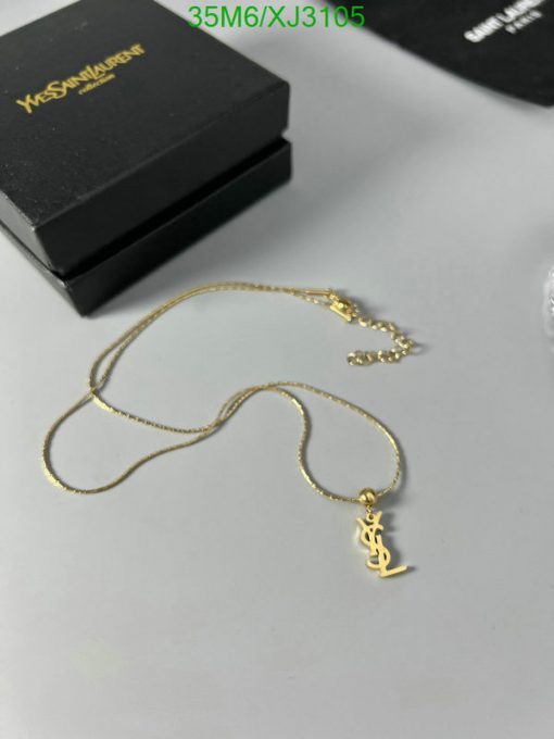 Gold anchor pendant necklace on white surface