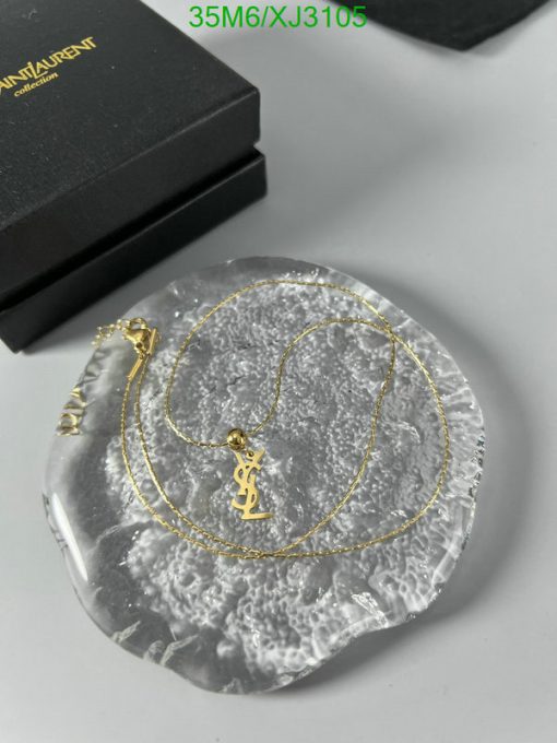 Gold necklace on textured dish, luxury branding.