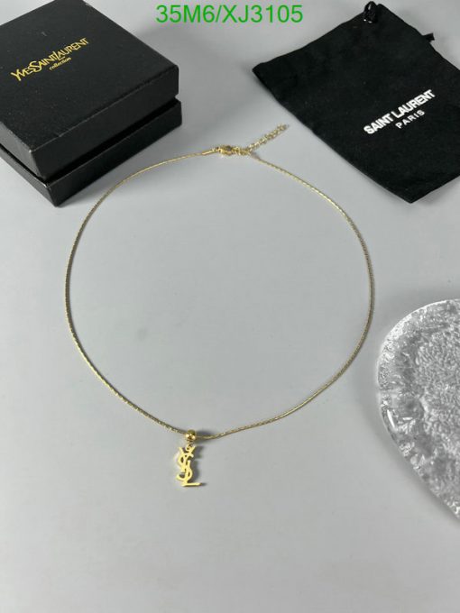 Gold necklace with pendant on white surface.