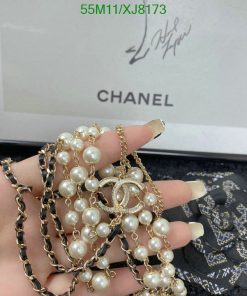 Holding Chanel pearl bracelet and necklace with signature.