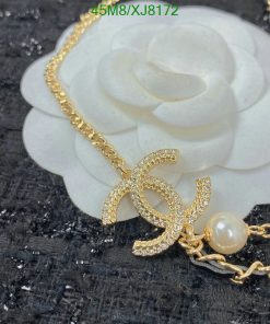 Gold necklace with pearl accents on floral background.