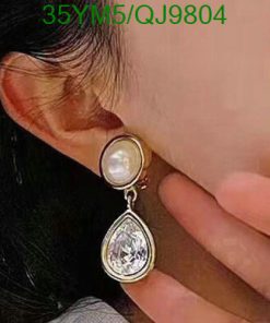 Woman wearing pearl teardrop earring.