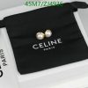 Celine pearl earrings on black pouch with branding.