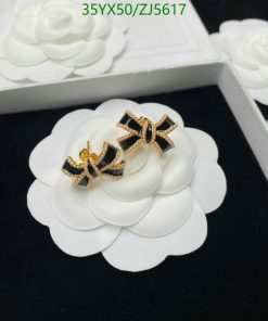 White floral earrings with gold bow accents on display.