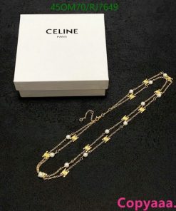 Celine gold necklace on black with white packaging box.