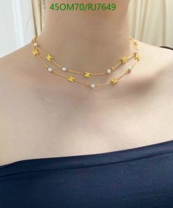 Gold layered necklace with pearls on woman's neck