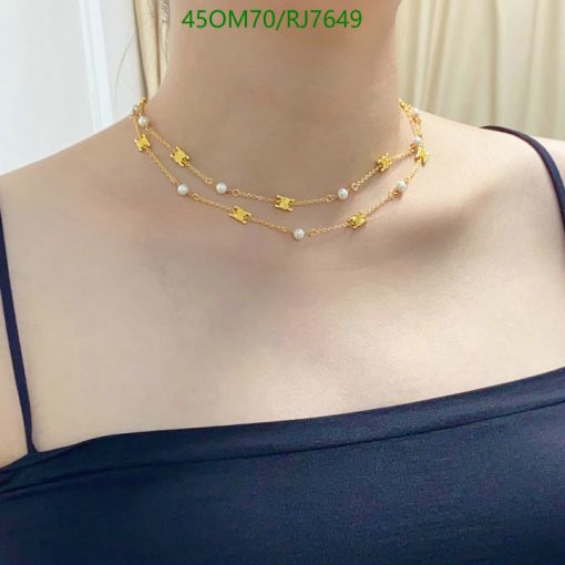 Gold layered necklace with pearls on woman's neck