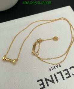 Gold barbell necklace on white surface.