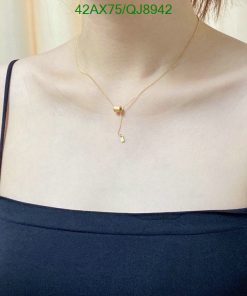 Golden pendant necklace on person's neck.