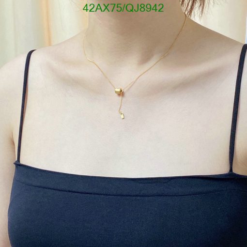 Golden pendant necklace on person's neck.