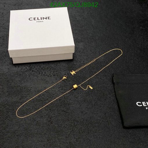 Celine gold necklace on black surface with box and pouch.