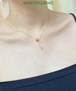 Gold pendant necklace on woman's neck