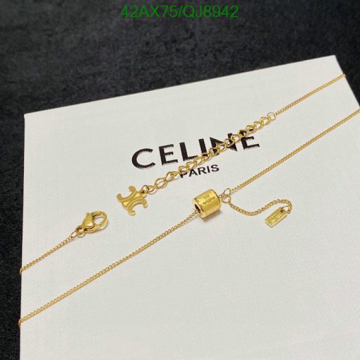 Gold necklace on branded Celine card.