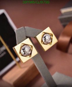 Gold diamond earrings on display stand.