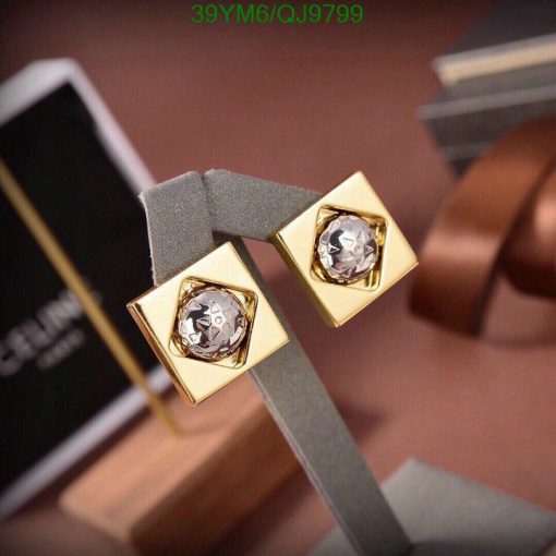 Gold diamond earrings on display stand.