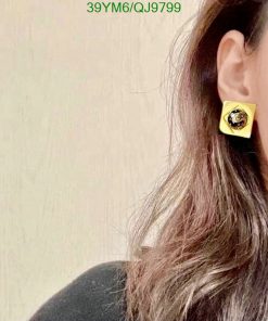 Woman wearing yellow square earring.