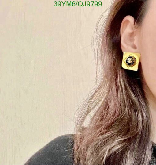 Woman wearing yellow square earring.