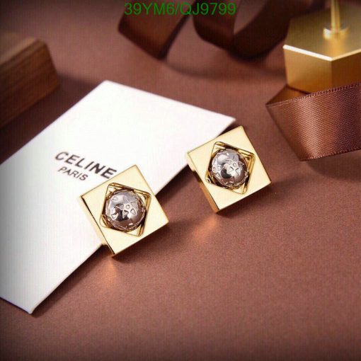 Designer gold earrings on luxury background.