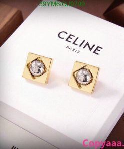 Gold Celine earrings on white display.