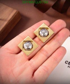 Gold diamond earrings on display with luxury branding.