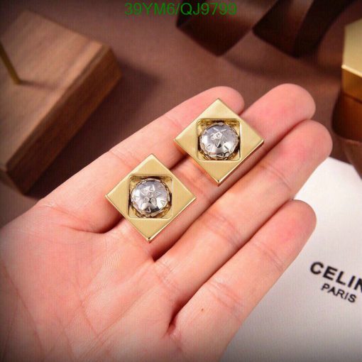 Gold diamond earrings on display with luxury branding.