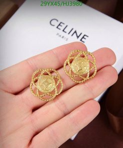 Gold coin earrings held above branded box.