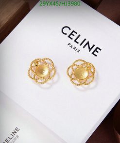 Celine gold earrings on white display.