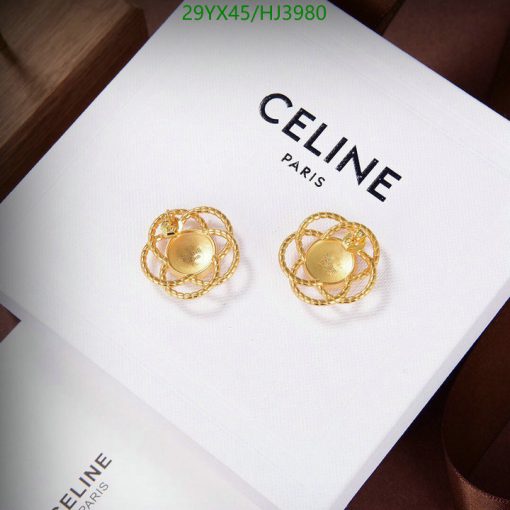 Celine gold earrings on white display.