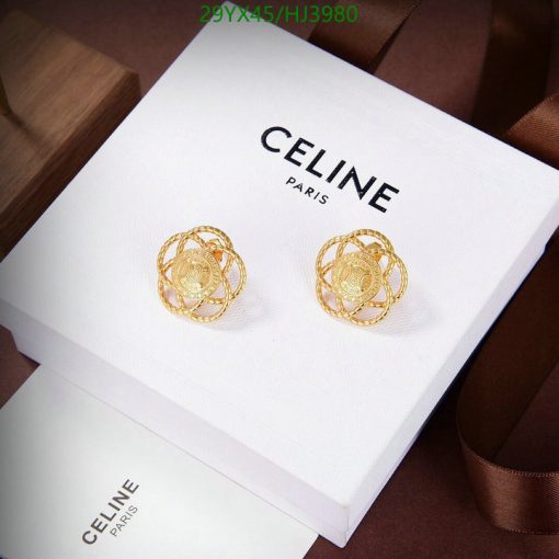 Celine gold earrings on white display box.