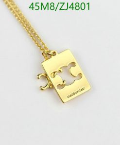 Gold puzzle piece pendant necklace on white background.