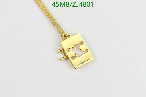 Gold puzzle piece pendant necklace on white background.