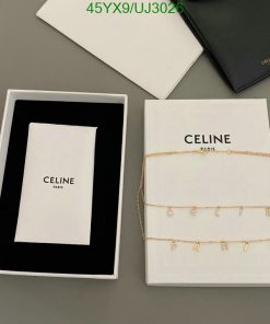 Celine jewelry box with gold chain on table.