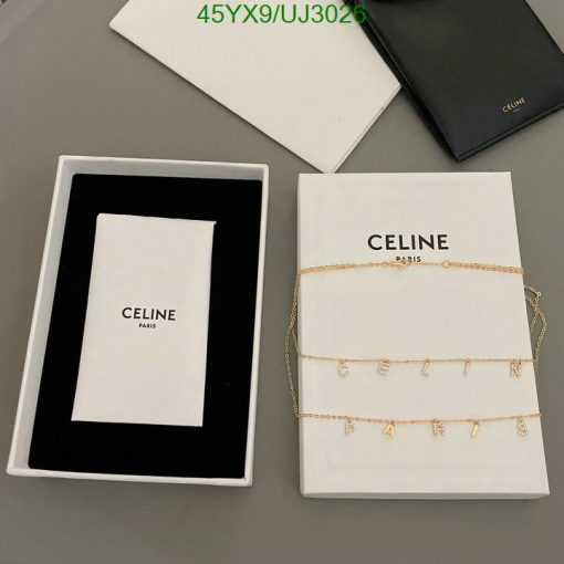 Celine jewelry box with gold chain on table.